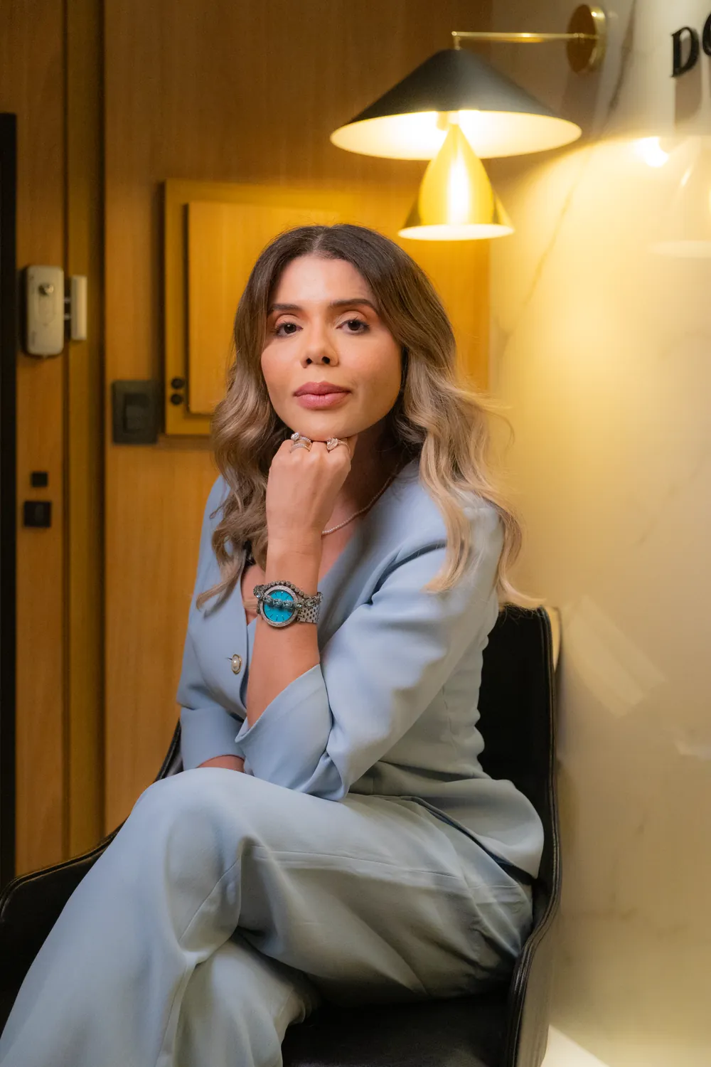 Geisiane Soares Dourado de terno azul-claro no escritório